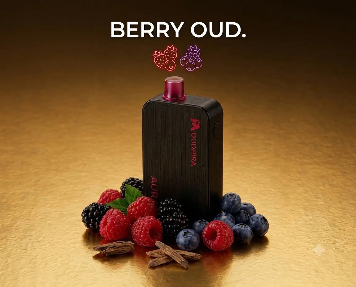 A black Aoudhrea vape device with a pink mouthpiece stands on a gold surface, surrounded by fresh berries and cinnamon sticks. The text 'BERRY OUD.